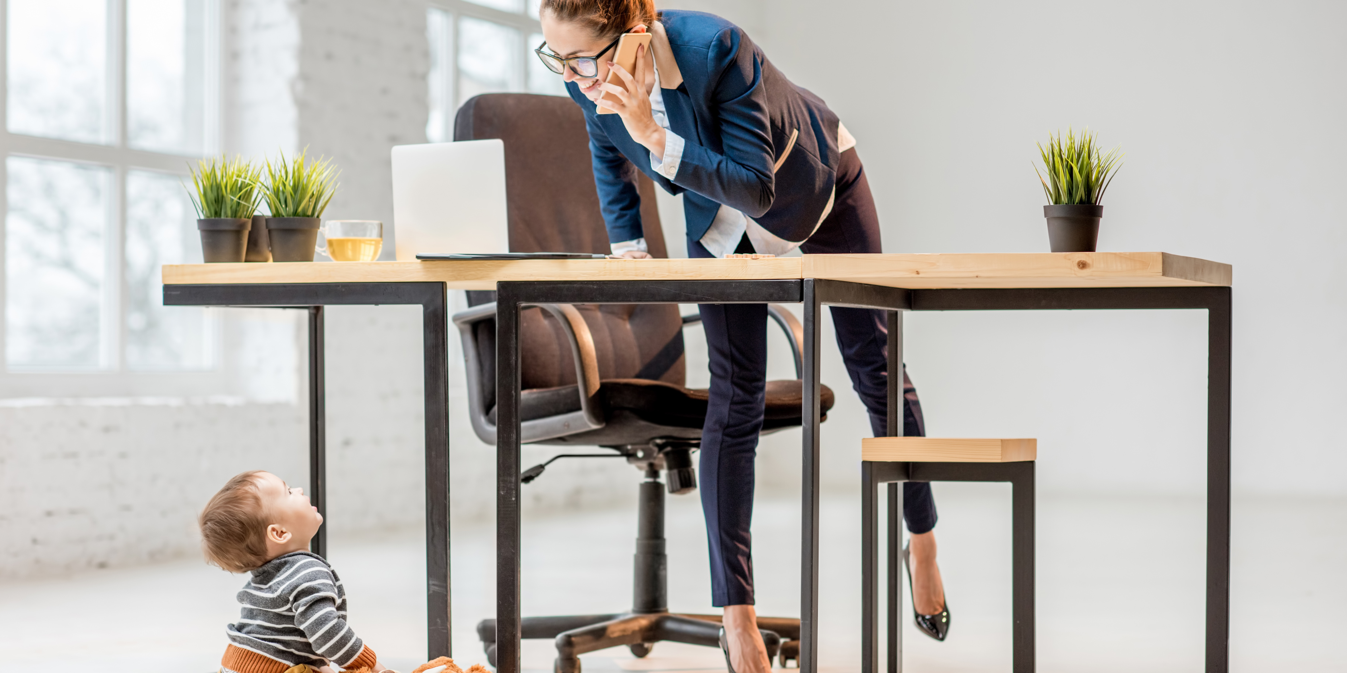 nanny with child multitasking at desk