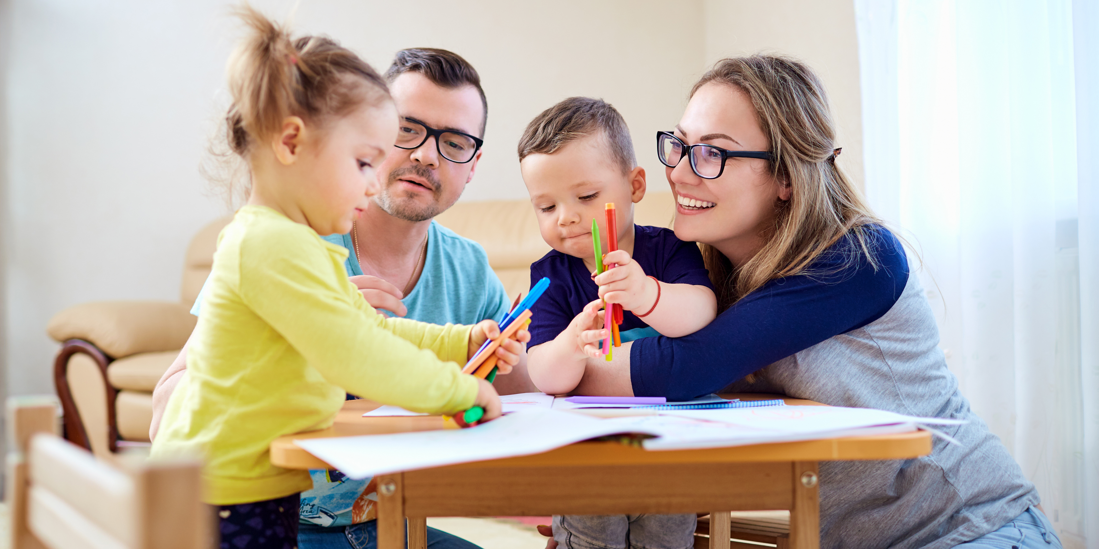 parents with two children coloring at a table